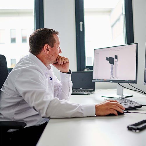 Sitzender Mitarbeiter vor einem Computer